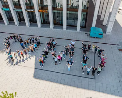 SWM Mitabeiter:innen stehen vor dem Gebäude und bilden den Schriftzug "Love MD"