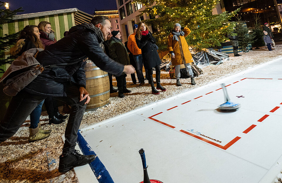 Gruppe beim Eisstockschießen auf dem SWM Weihnachtsmarkt