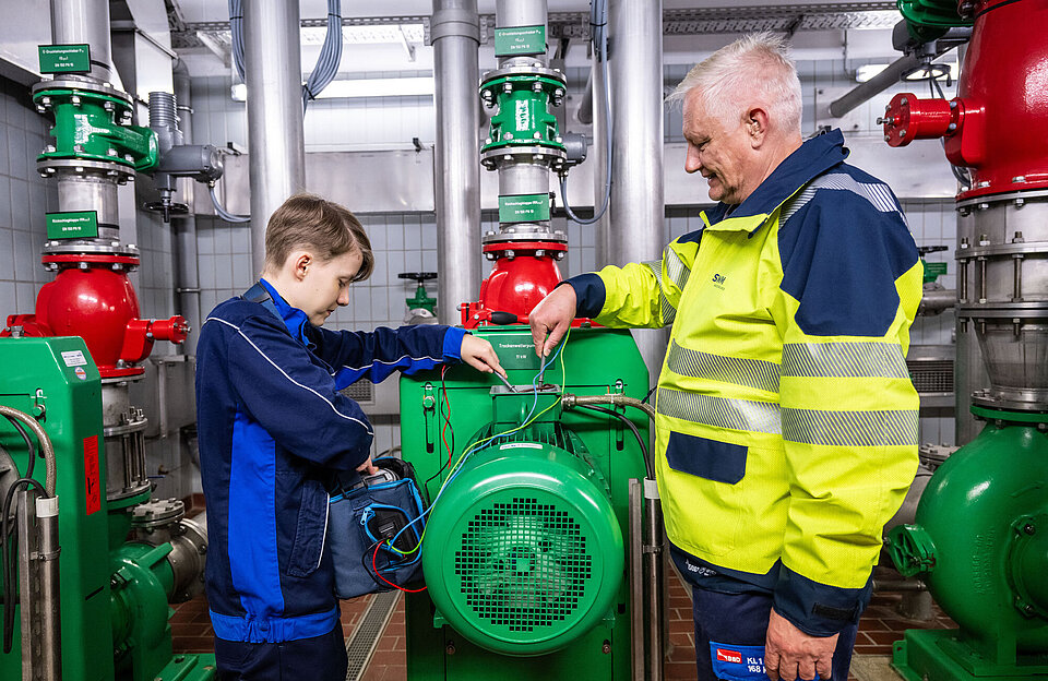 SWM Mitarbeiter und Elektroniker Auszubildender zusammen bei der Arbeit