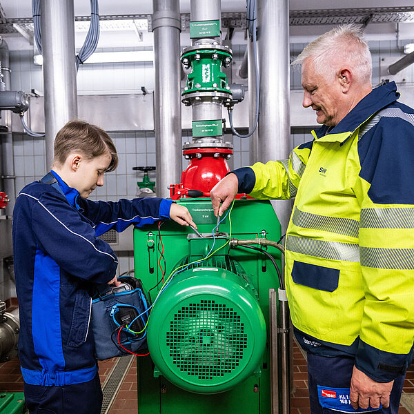 SWM Mitarbeiter und Elektroniker Auszubildender zusammen bei der Arbeit