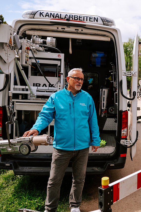 SWM Mitarbeiter erklärt Kunden die Kanal-TV-Kamera