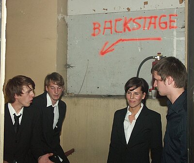 Band Violent Red steht zusammen vor Schild "Backstage"